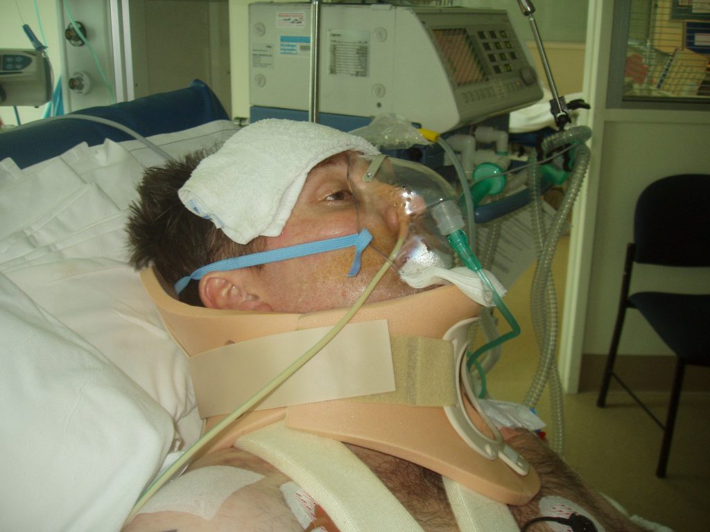wheelchair john duthie - In ICU with a neck brace, many tubes and equipment