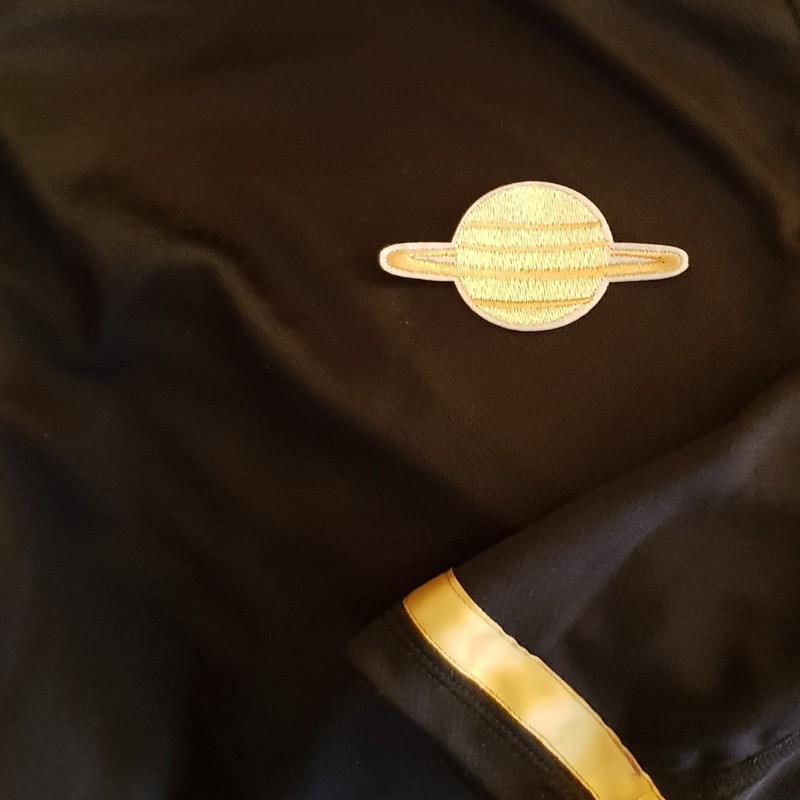 Galactic Trek: The Search for Zork - the image for the show with a brown shirt and a badge that looks like saturn. Adelaide Access Taxis