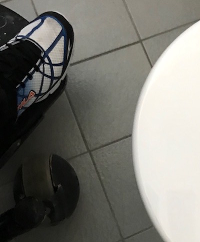 my foot is to the left, and the white toilet