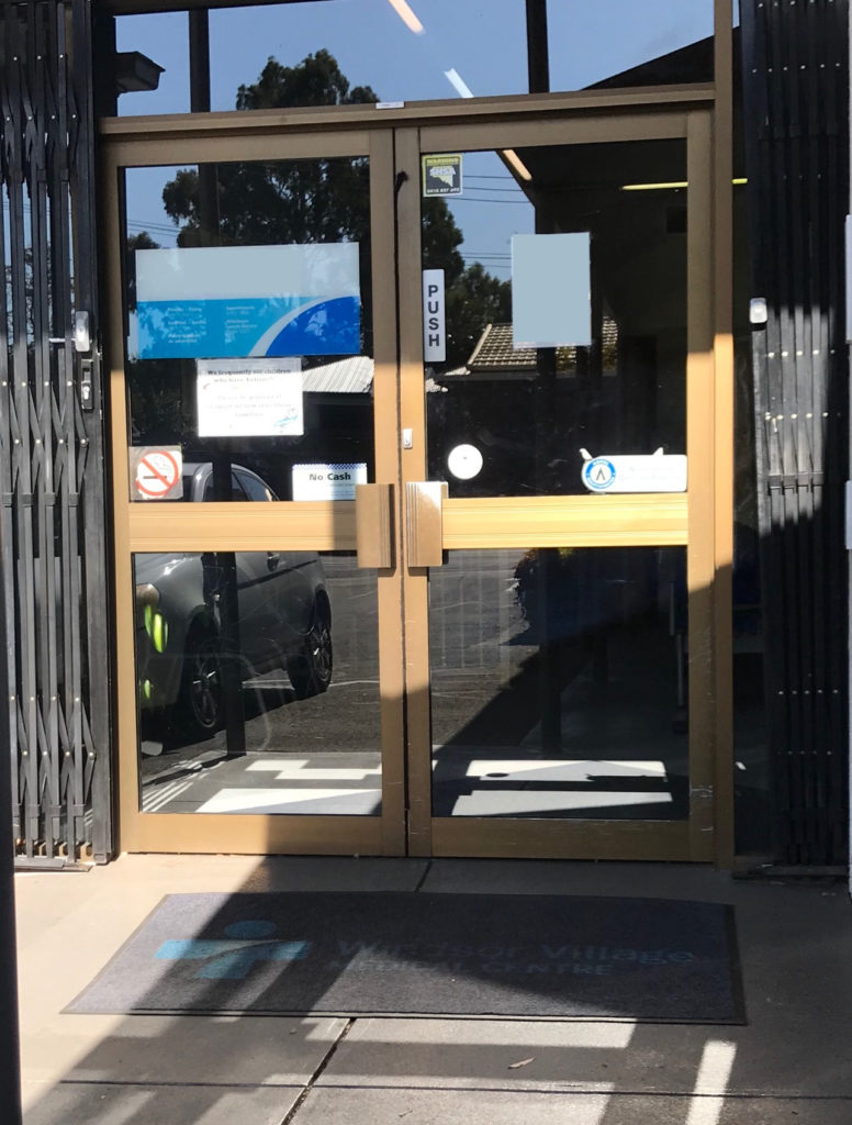 A slight incline to the front door, and the double doors are brown with a large handle. 2 planes of glass on each door