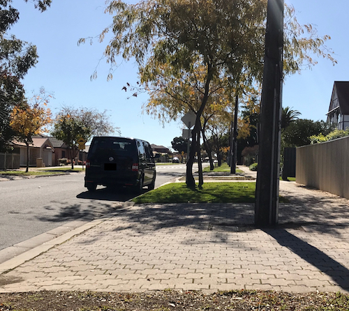 my black vw transporter is parked on the wrong side of the road. Next to grass and trees.
