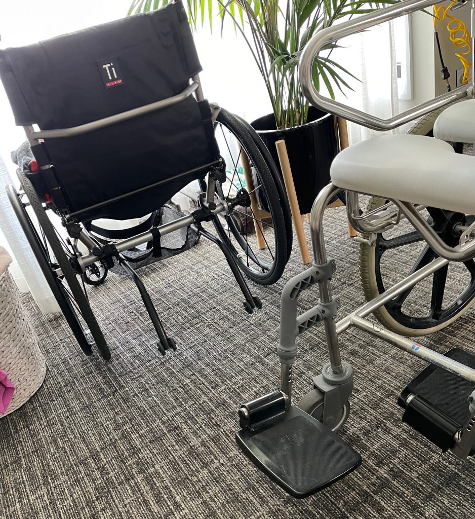 manual chair in window area and too far from me, and shower chair to the right.