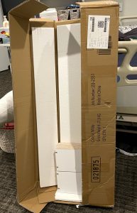 rectangular cardboard box has just been opened with foam now exposed that protects the content