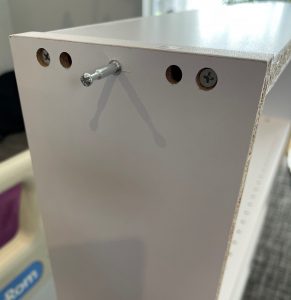 the pin is sticking out of the top of the bookshelf